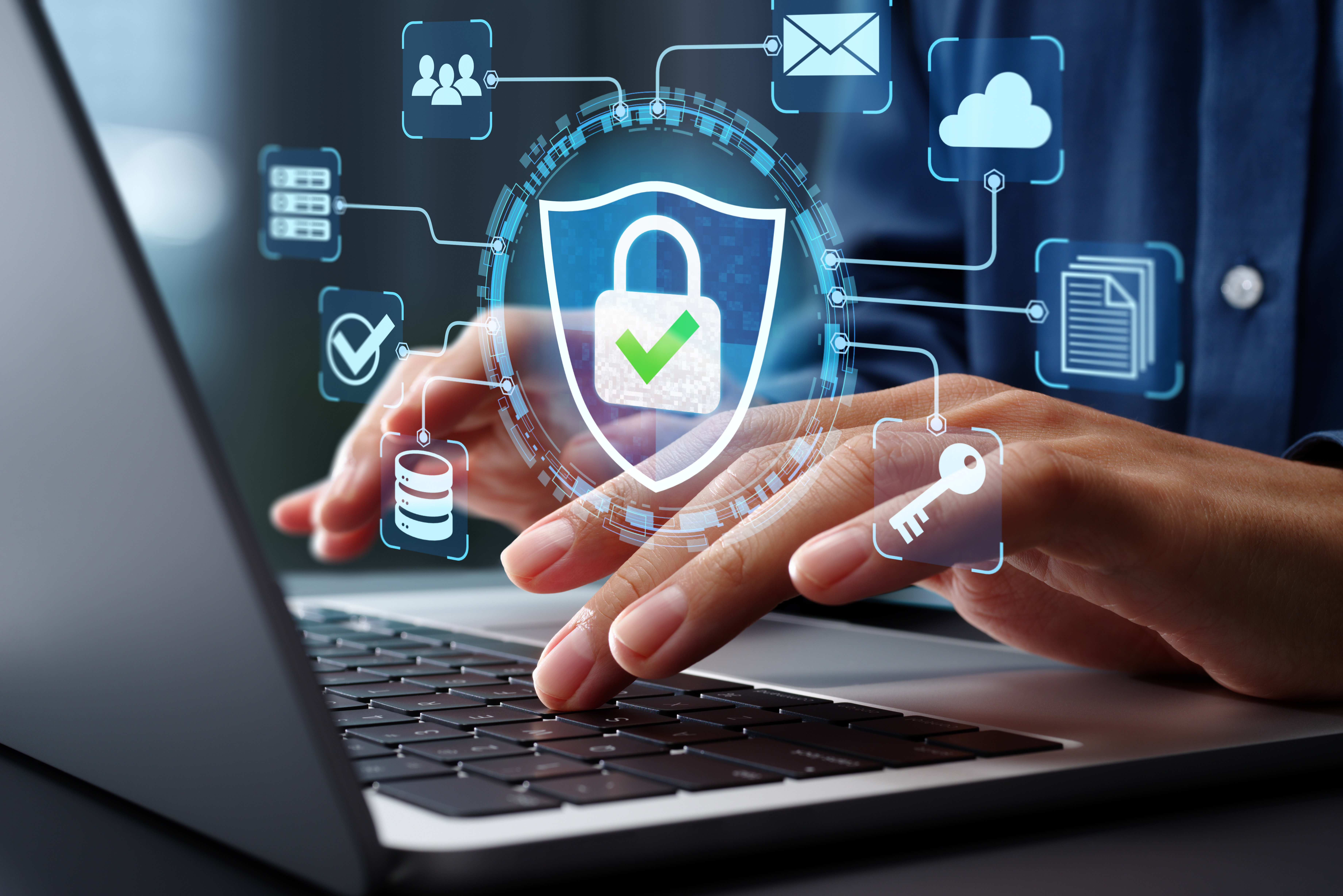 Person typing on laptop with holographic cybersecurity elements floating.